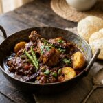 Authentic Bengali Chicken Kosha with tender chicken and potatoes in rich caramelized gravy served with luchi