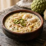 Creamy chilled Sitaphal Rabdi custard apple dessert garnished with pistachios, almonds, and saffron