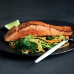 Crispy caramelized air fryer salmon bites with tender-crisp roasted broccoli florets on a plate with lemon