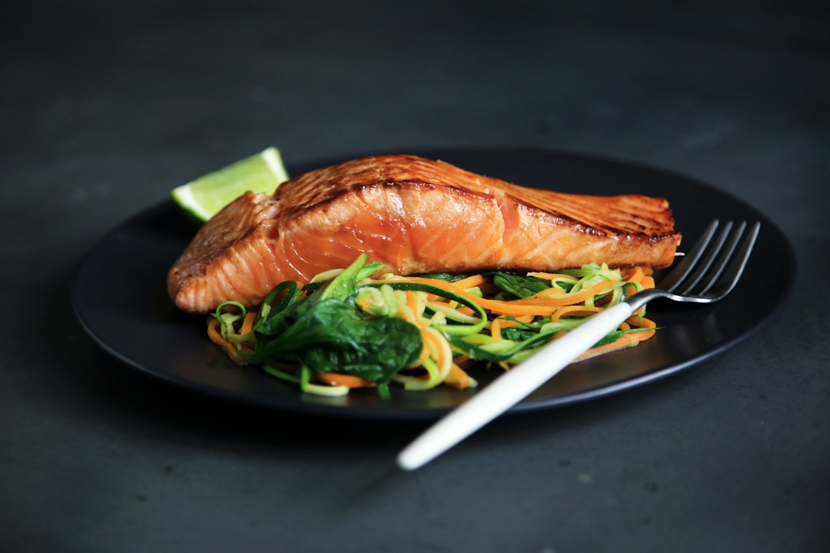 Crispy caramelized air fryer salmon bites with tender-crisp roasted broccoli florets on a plate with lemon