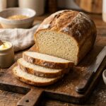 Sliced soft homemade gluten-free sandwich bread on a wooden board with butter and knife