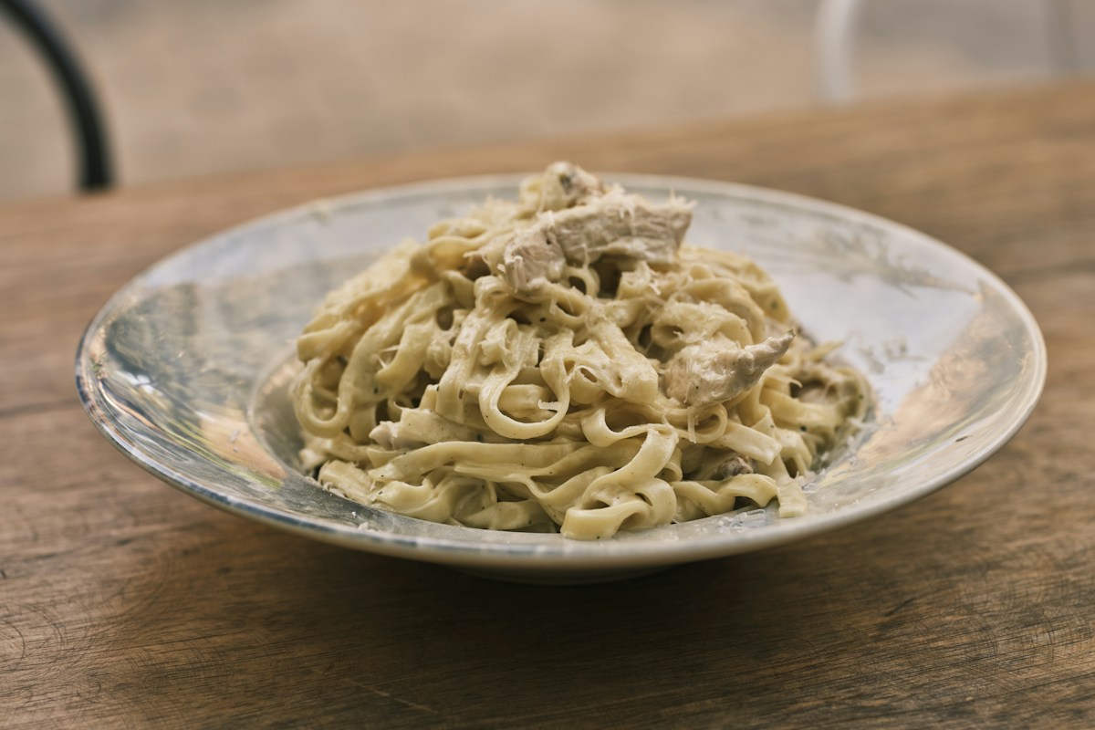 Fettuccine pasta swirled in silky homemade white Alfredo sauce topped with freshly grated Parmesan and chopped parsley