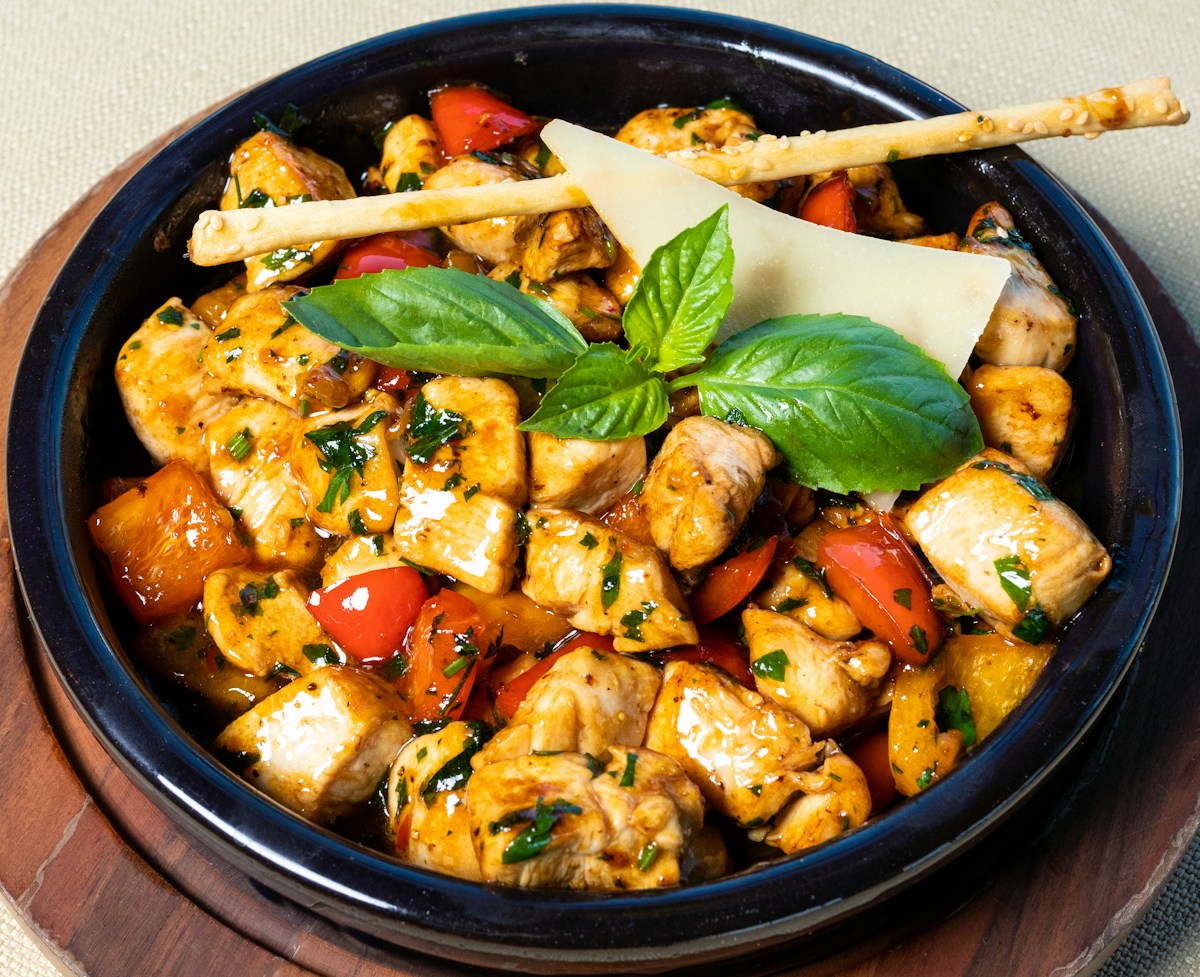 Juicy golden seared chicken breasts in a lemon herb garlic pan sauce with cherry tomatoes and spinach in a cast iron skillet