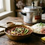 Authentic Punjabi Rajma Masala curry in a bowl next to a pressure cooker and basmati rice
