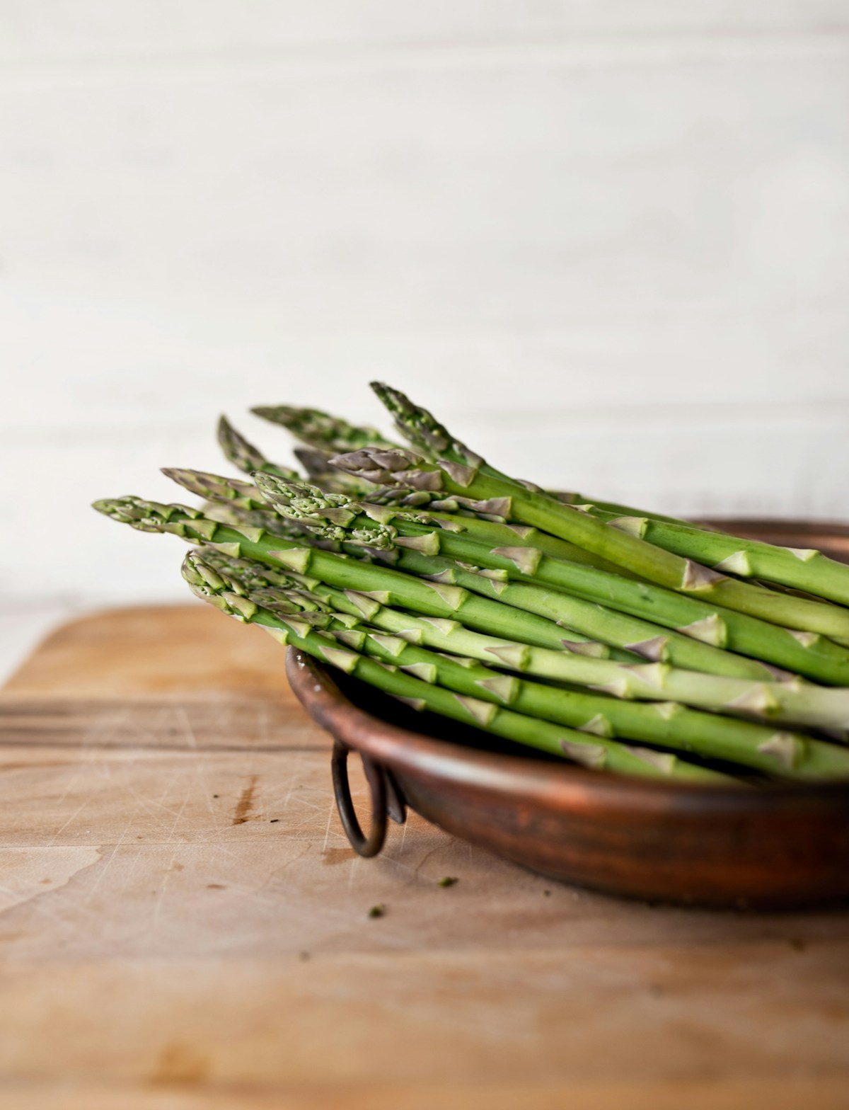 Tender-crisp roasted green asparagus spears on a sheet pan seasoned with olive oil, minced garlic, and parmesan cheese