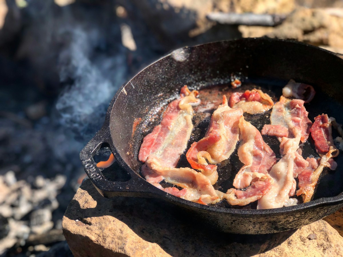 Perfect flat crispy oven-baked bacon strips drained on brown parchment paper