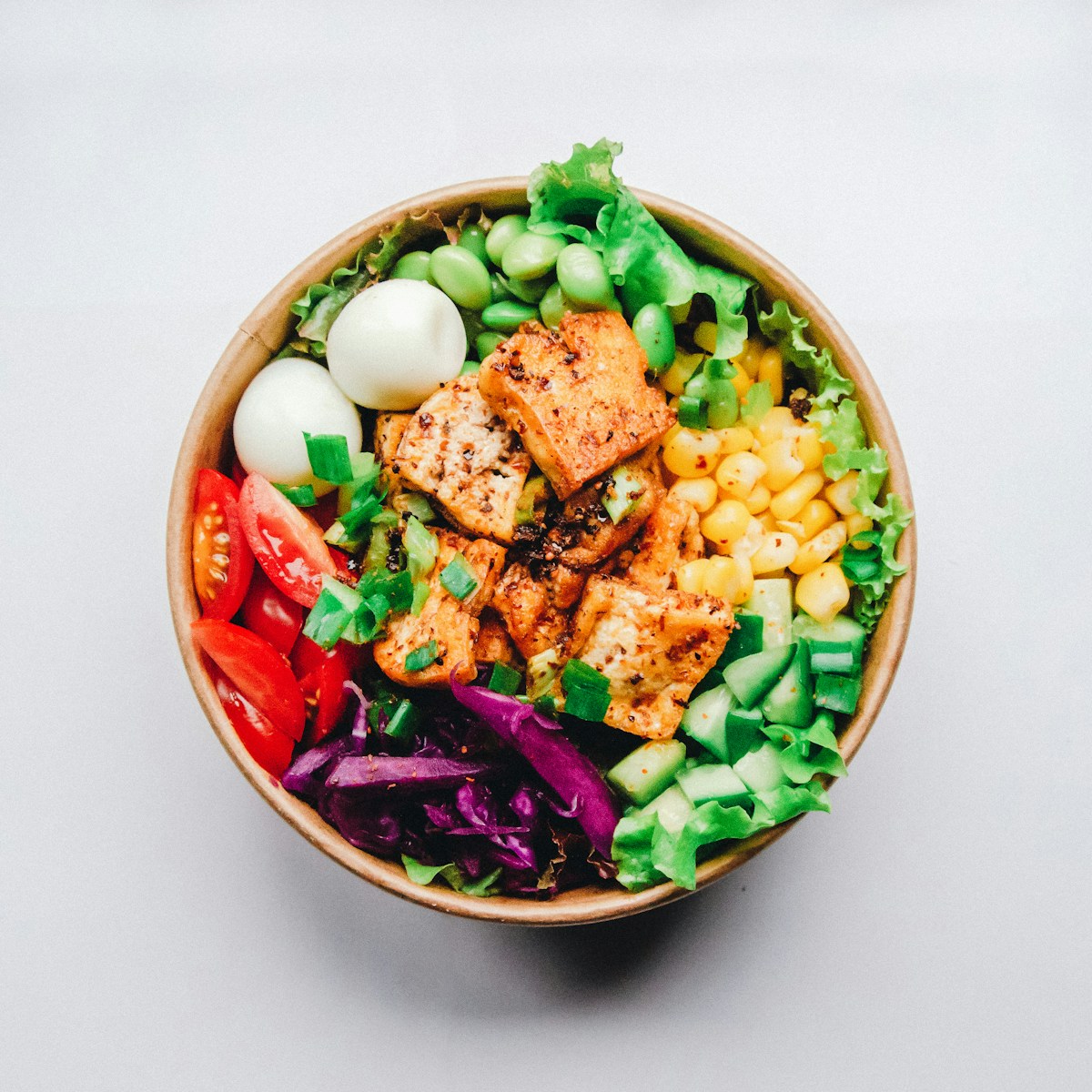 A bowl of hearty, nutty cooked pearl barley topped with herbs and roasted vegetables
