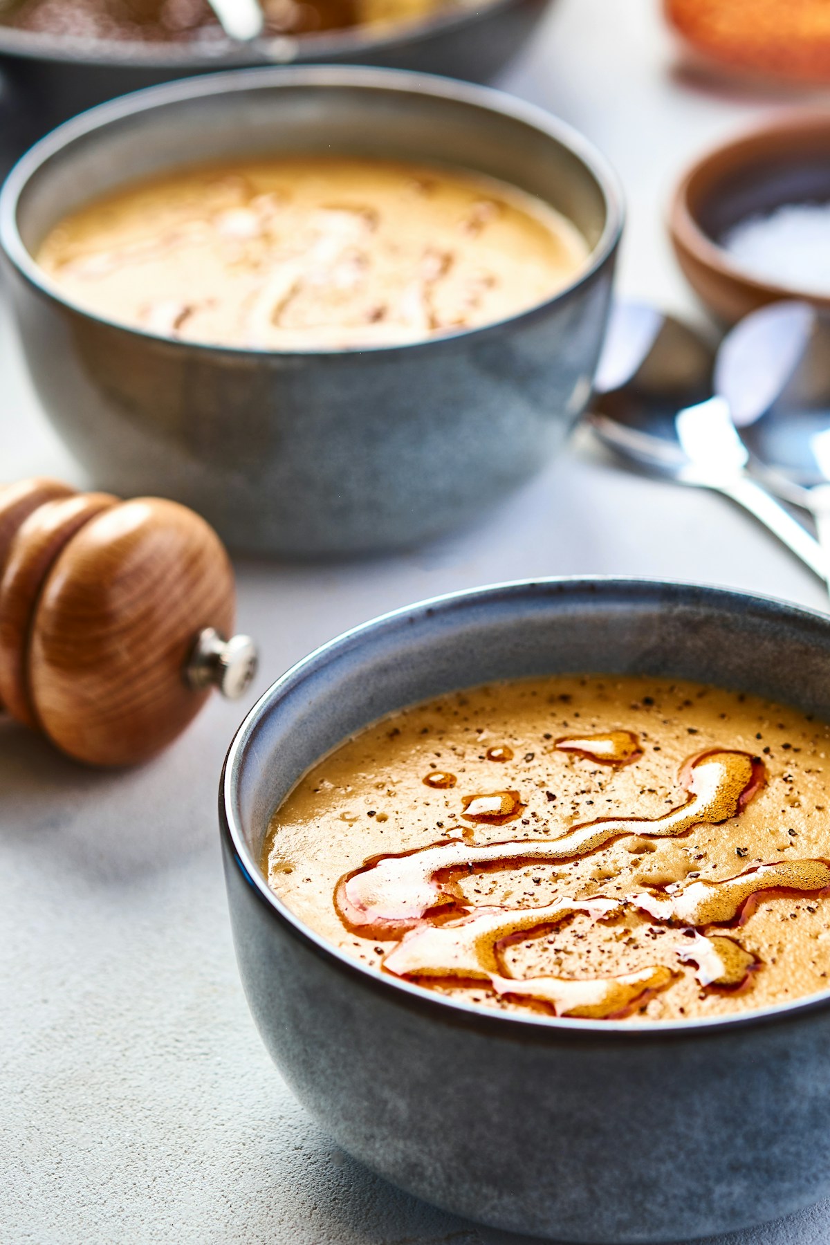 A rustic ceramic bowl filled with tender seasoned brown and green lentils simmered with garlic and bay leaf
