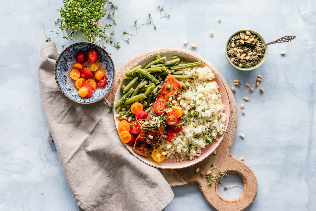 A chef tasting and thickening a rich savory sauce in a warm pot with fresh herbs and spices