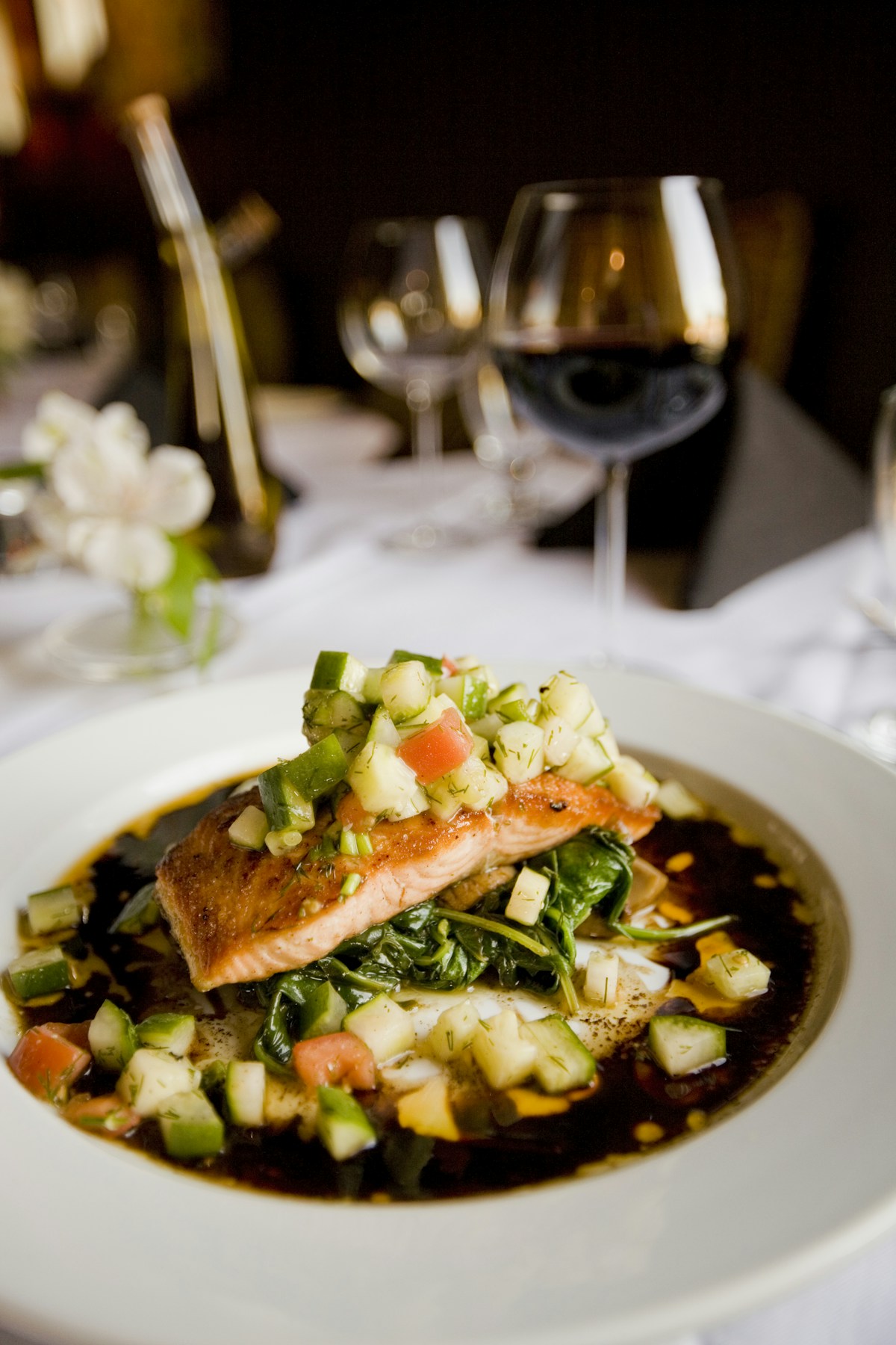 Pan-seared crispy skin salmon fillet with fresh dill sprigs and lemon wedges